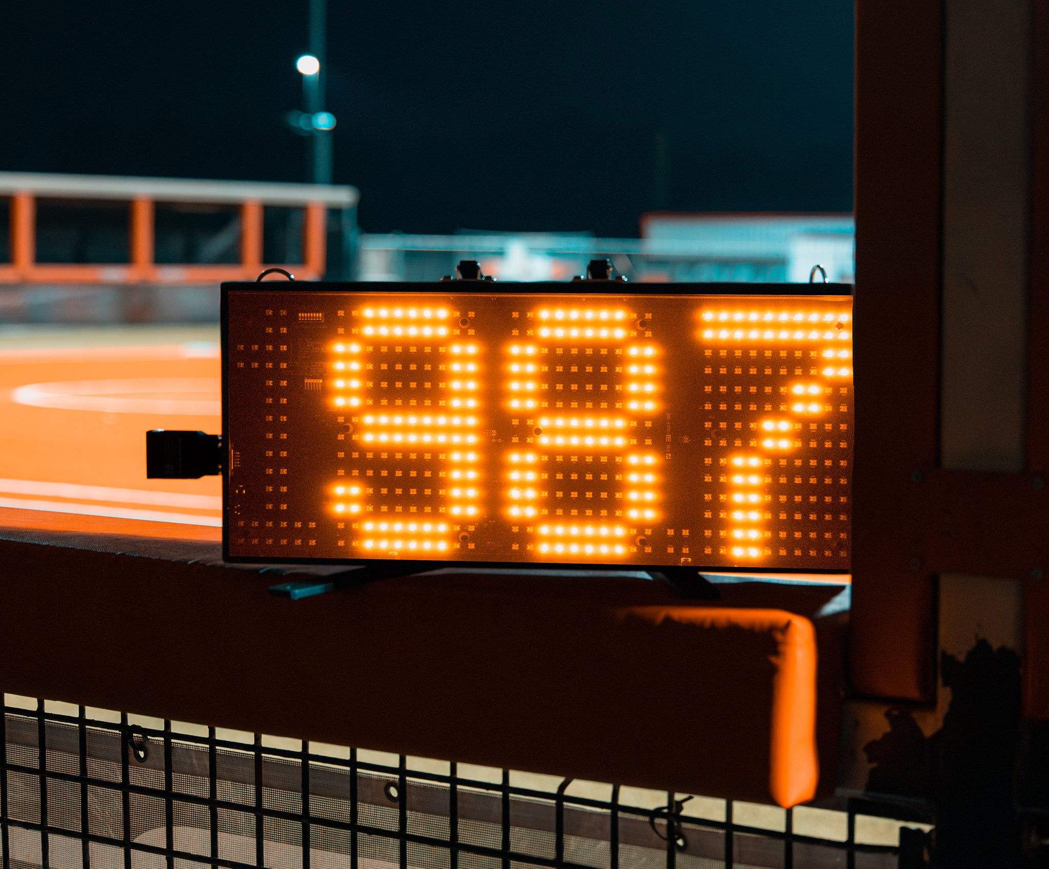 A 3.5 Digit LED Speed Sign from Stalker Sport sitting on a wall in a baseball stadium at night.