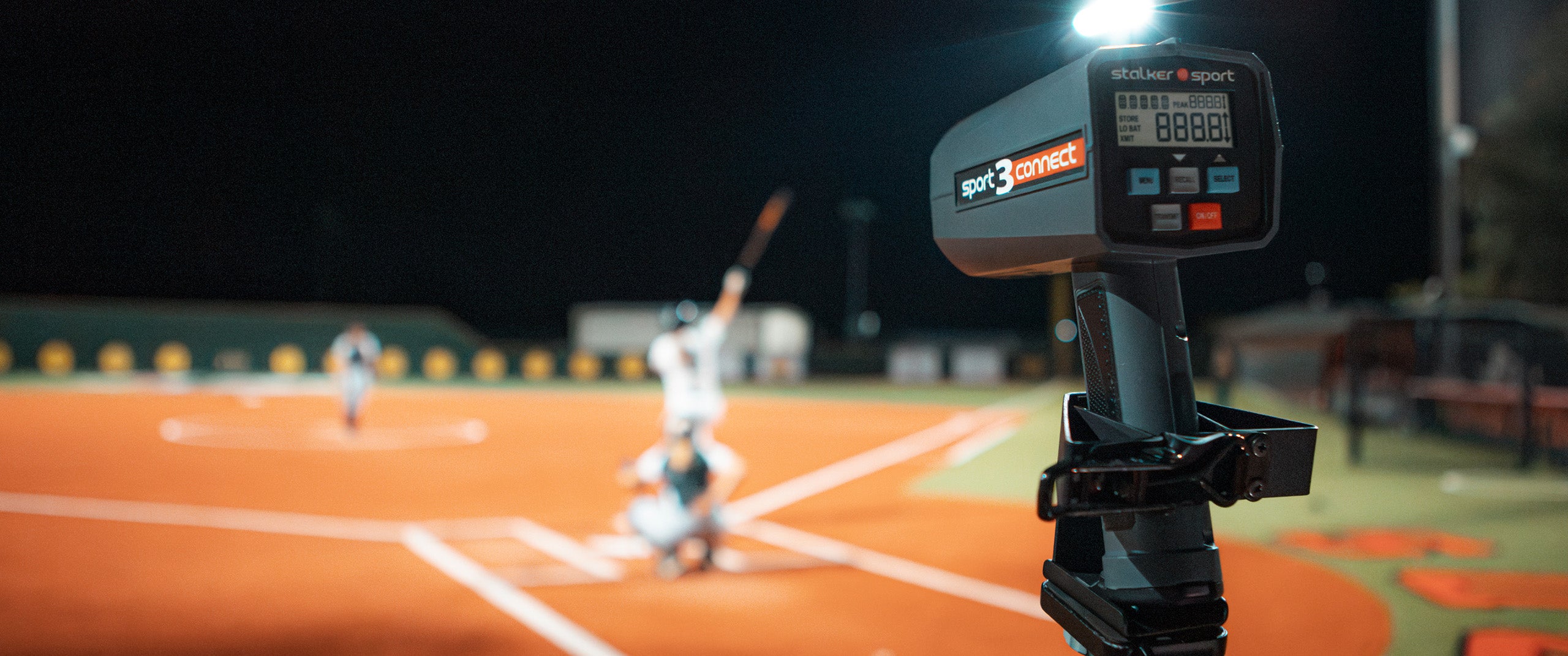 A Sport 3 Connect mounted in the 4-in-1 mount pointed towards a softball game at night.