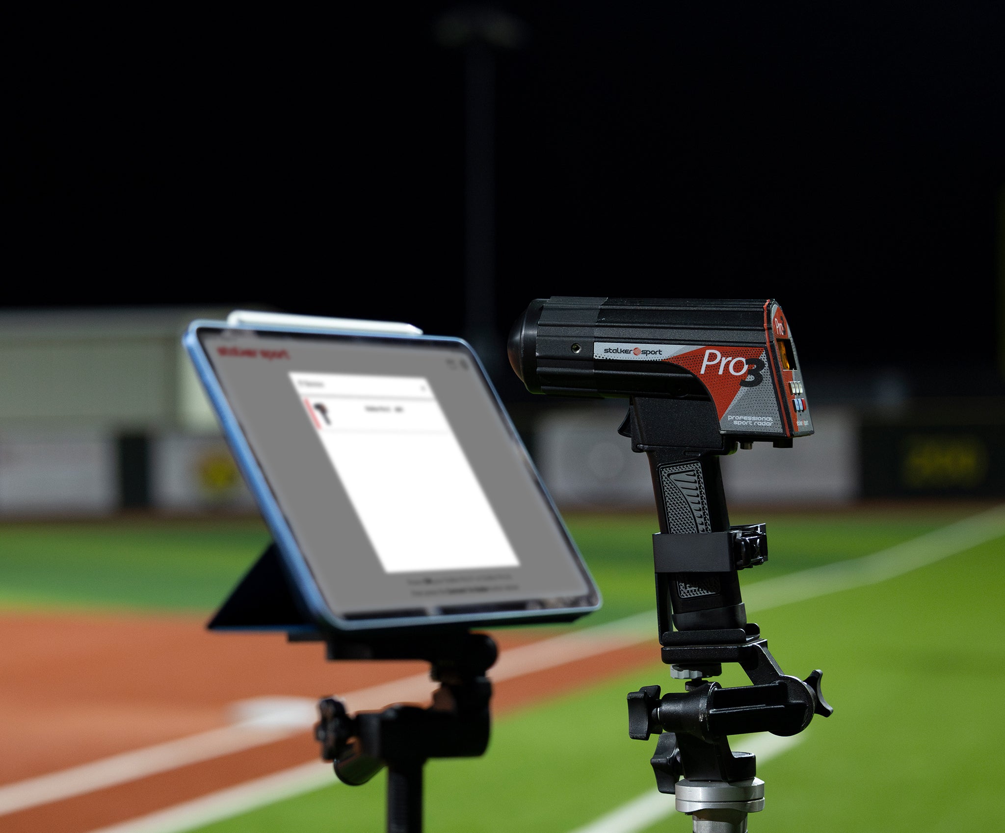 A Stalker Sport Pro 3 radar gun in a tripod mount next to an iPad on a tripod connecting to the Stalker Sport Radar iOS app.