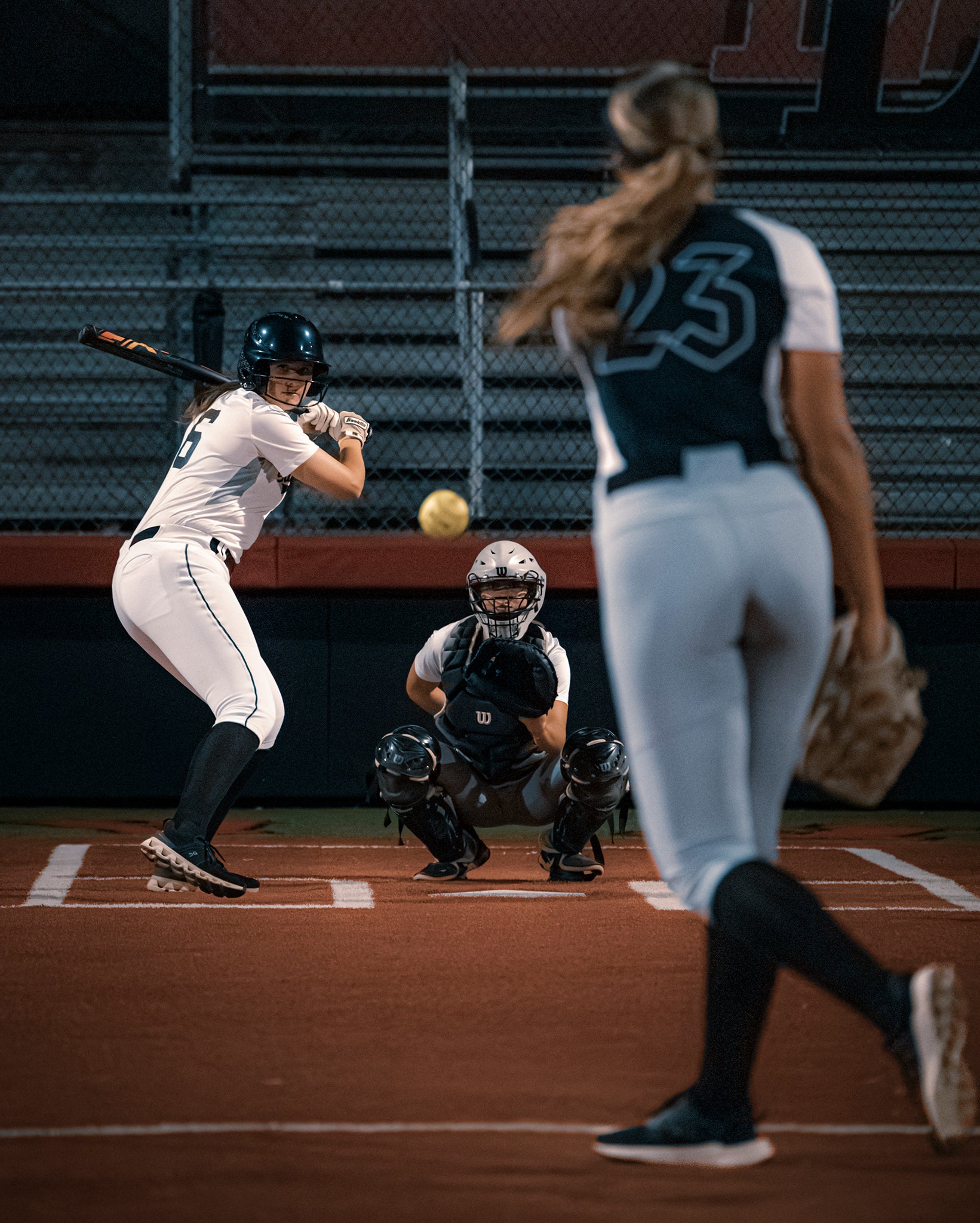 Team Stalker Sport playing softball. A pitch is in mid-air and the batter is getting ready to hit it.