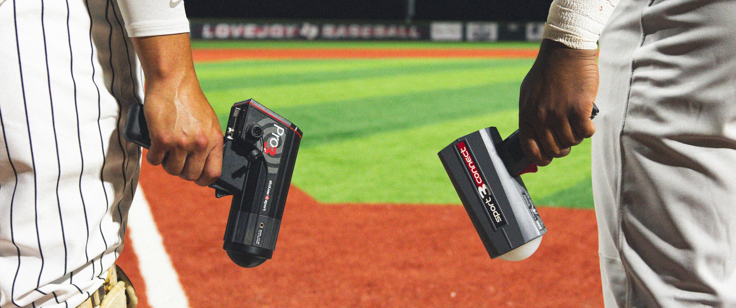 Two baseball players holding Stalker Sport radar guns. The player on the right is holding a Pro 3s and the player on the left is holding the Sport 3 Connect.