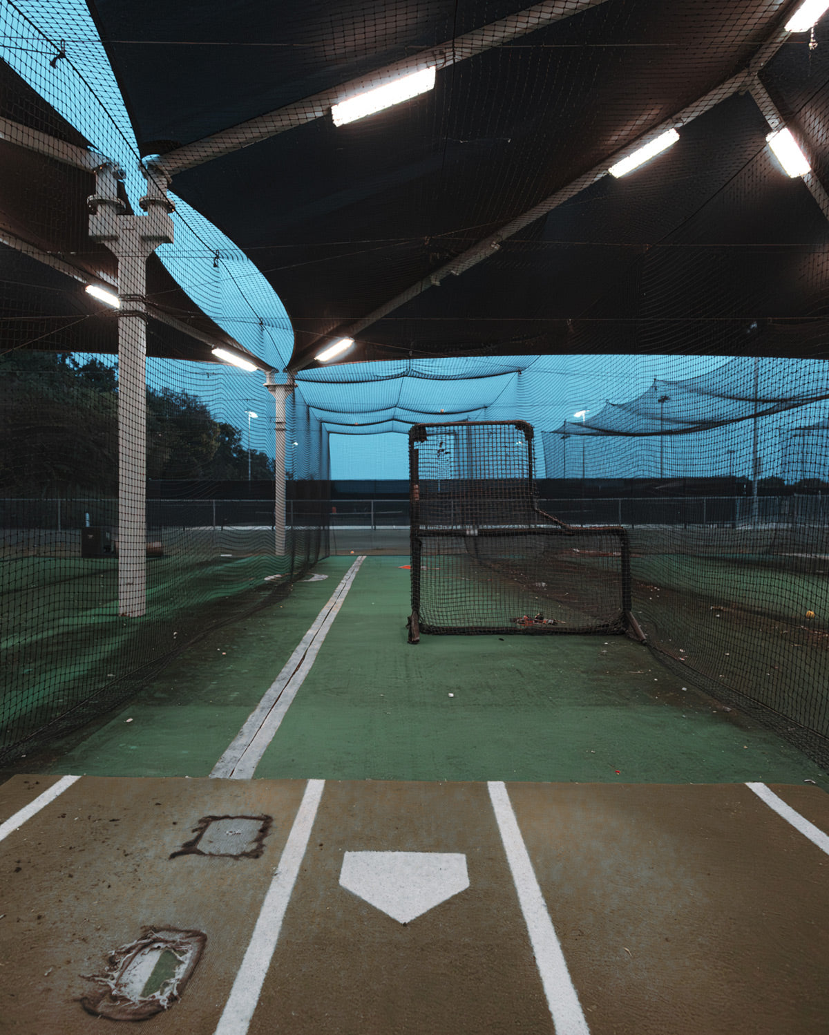 Stalker Sport photo of an empty batting cage in the evening.