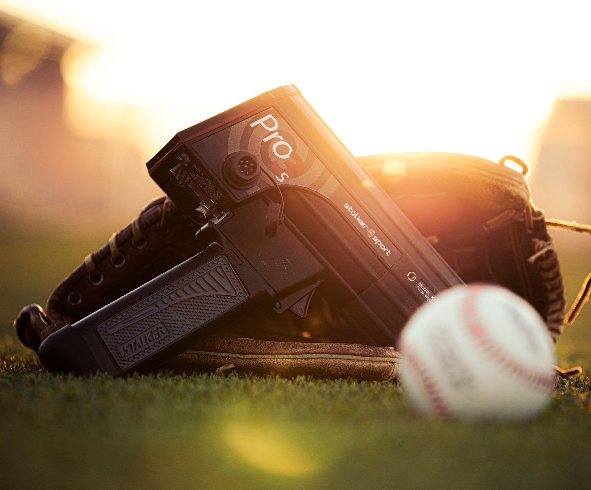 A Stalker Sport Pro 3s in a baseball glove on a baseball field beside a baseball.