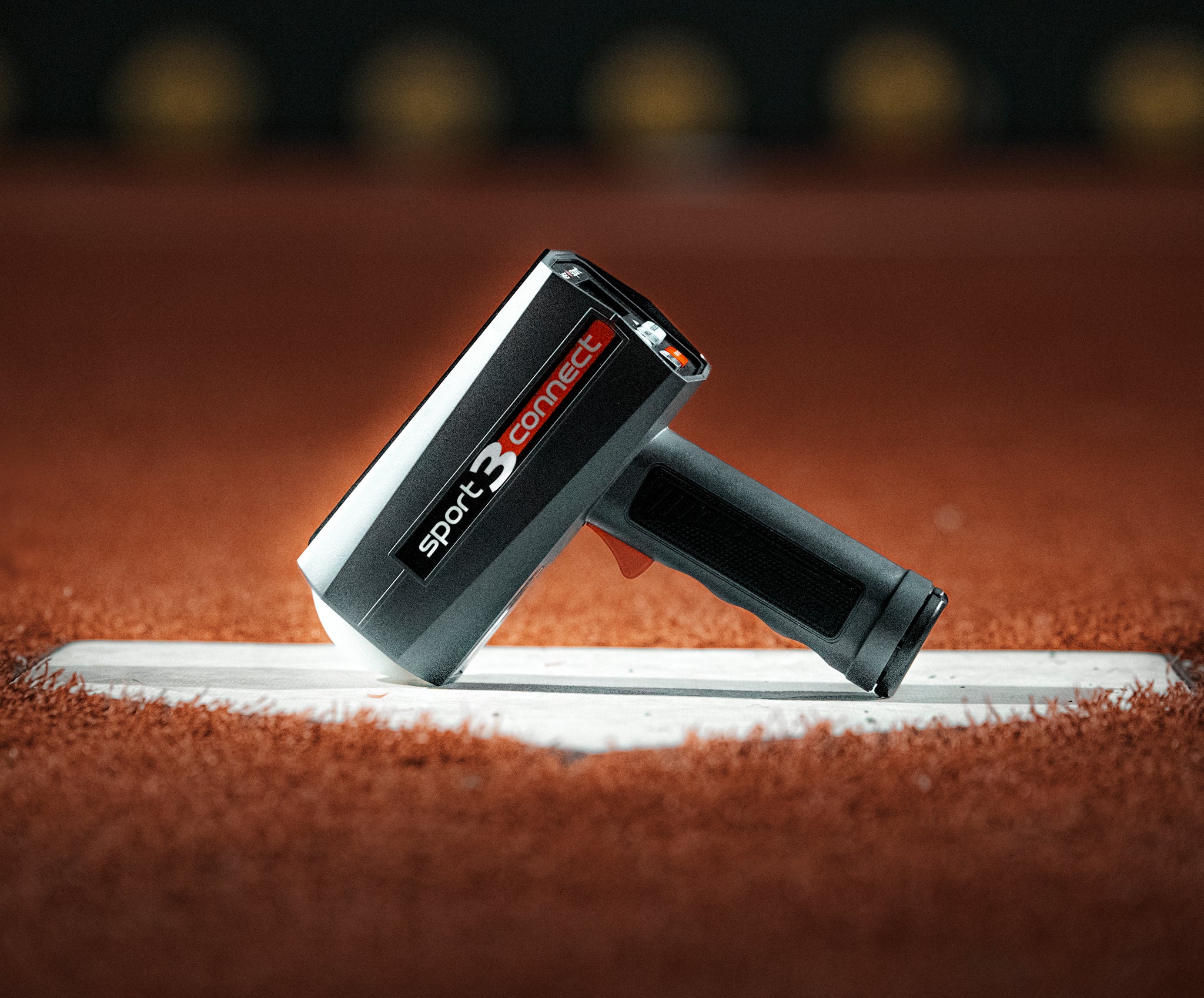 A Sport 3 Connect radar on a base surrounded by brown artificial turf.